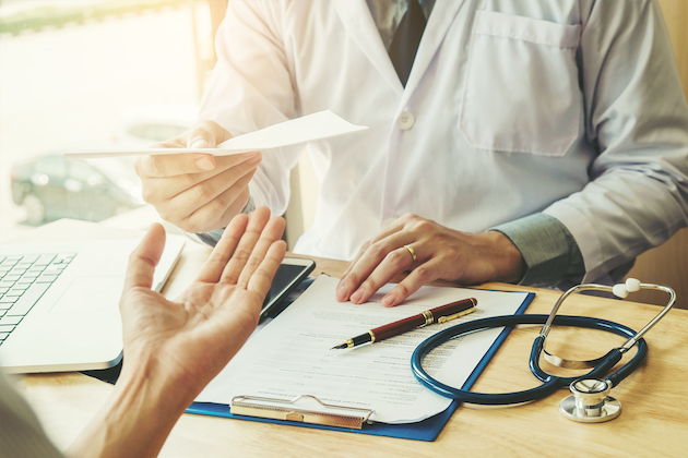 A clinician handing over a paper.