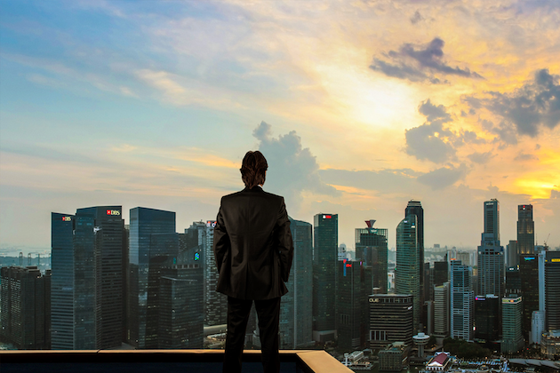 Suited man taking in panoramic view of urban landscape.
